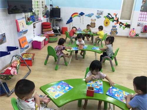 Bé tập cầm bút di màu
